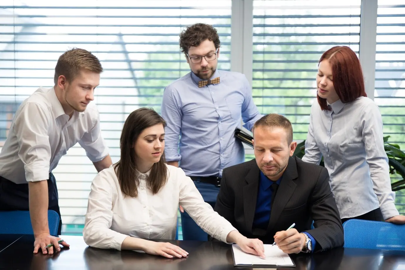 Pearl Lemon sales team gathered around a desk reviewing strategy documents during a planning session.