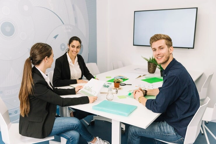 Pearl Lemon sales team in a casual strategy meeting, reviewing marketing documents and smiling during discussion.